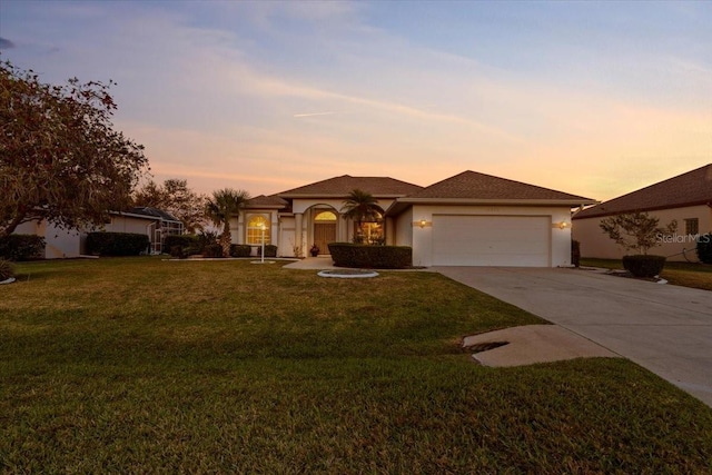 view of front of house featuring a front yard, an attached garage, driveway, and stucco siding