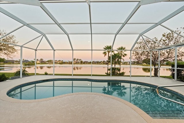 pool with a lanai, a patio area, and a water view