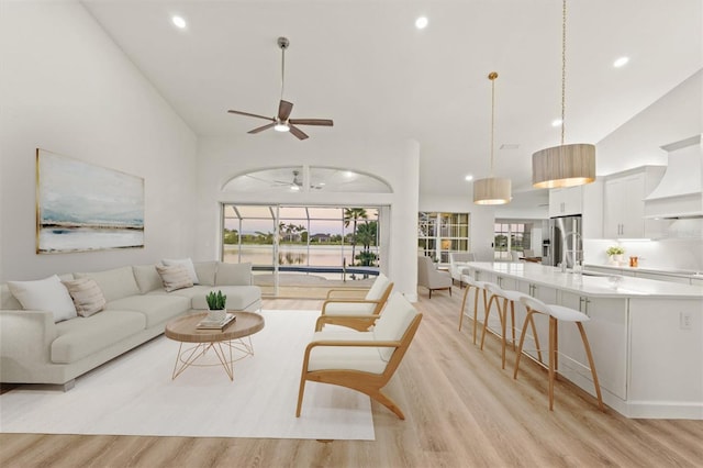 living room featuring a wealth of natural light, light wood-style flooring, and a ceiling fan