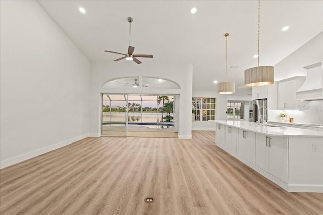 unfurnished living room featuring recessed lighting, baseboards, light wood-type flooring, and a ceiling fan