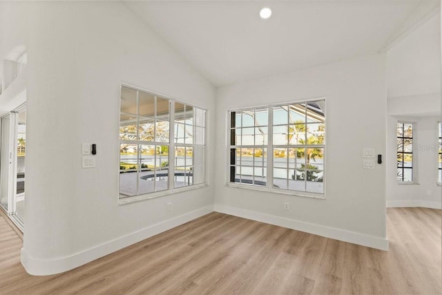 unfurnished dining area featuring lofted ceiling, light wood finished floors, baseboards, and a wealth of natural light