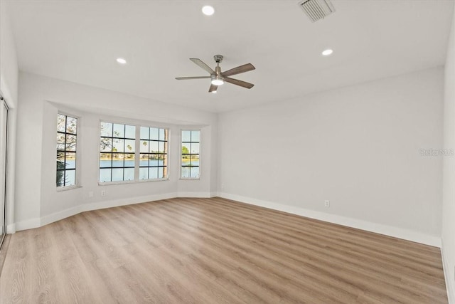 unfurnished room featuring visible vents, a healthy amount of sunlight, light wood-style floors, and a ceiling fan