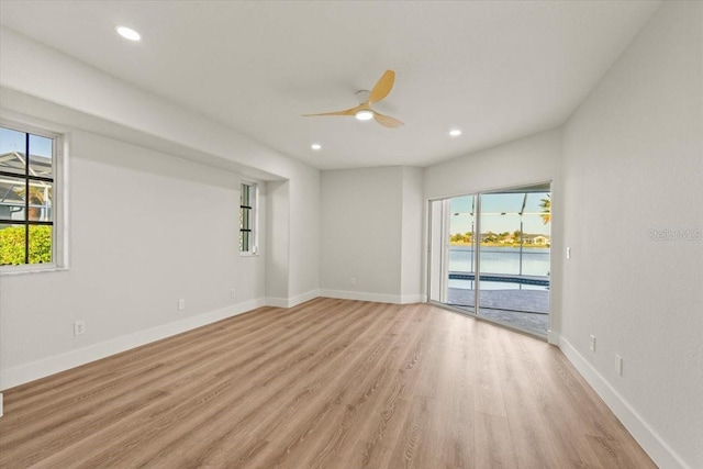 unfurnished room with a healthy amount of sunlight, a ceiling fan, light wood-type flooring, and baseboards