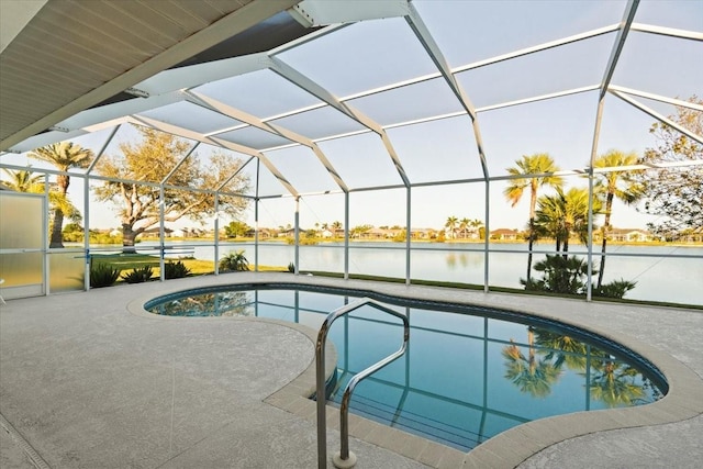 outdoor pool featuring a lanai, a patio area, and a water view