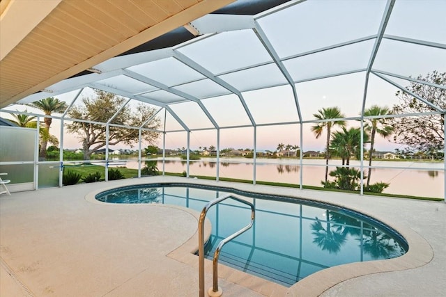 pool at dusk with glass enclosure, a patio, an outdoor pool, and a water view