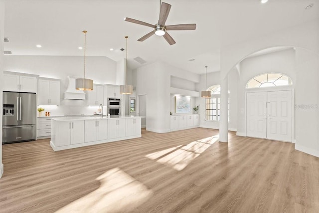 12800 SW Pembroke Cir N, Lake Suzy, FL 34269 - unfurnished living room featuring high vaulted ceiling, arched walkways, light wood-type flooring, a ceiling fan, and a sink