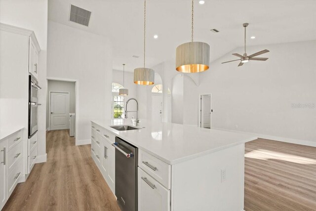12800 SW Pembroke Cir N, Lake Suzy, FL 34269 - kitchen featuring a sink, stainless steel appliances, high vaulted ceiling, an island with sink, and light wood finished floors