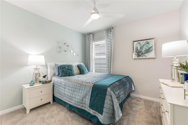 bedroom with light colored carpet, a ceiling fan, and baseboards