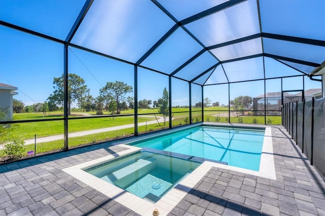 view of pool featuring glass enclosure, a lawn, a patio area, and a pool with connected hot tub