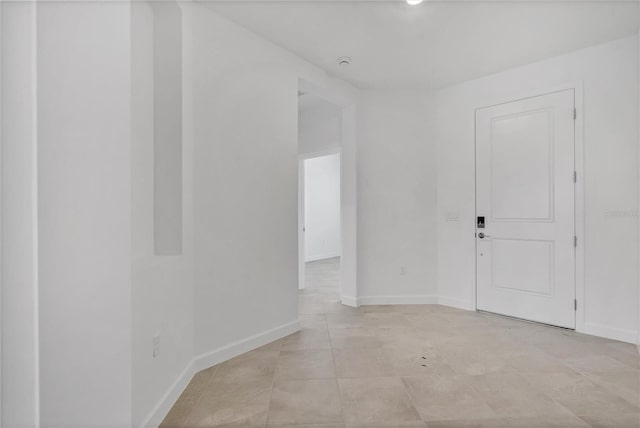 unfurnished room with baseboards