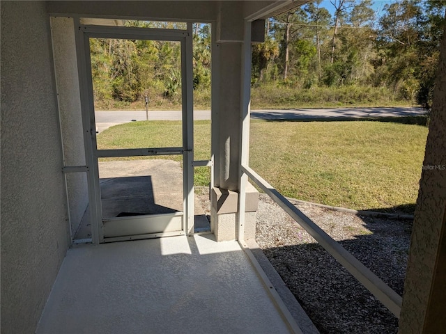 doorway to outside featuring concrete floors and a textured wall