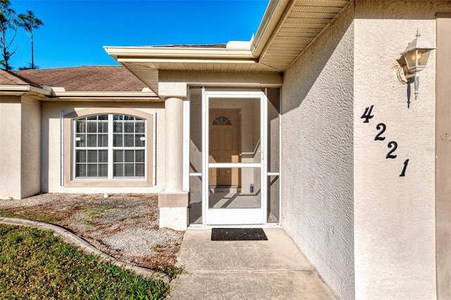 entrance to property featuring stucco siding