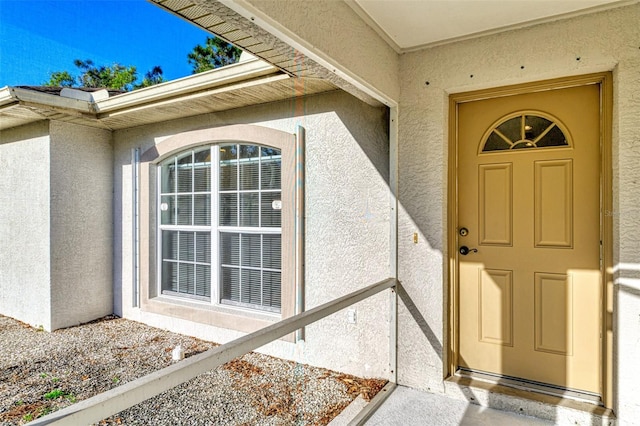 doorway to property featuring stucco siding