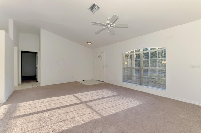 unfurnished room with visible vents, light colored carpet, lofted ceiling, and ceiling fan