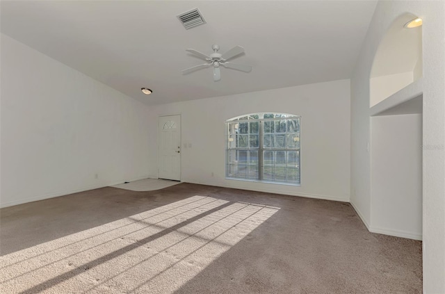 unfurnished room with carpet, a ceiling fan, visible vents, and baseboards