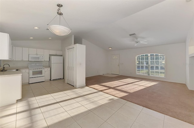 kitchen featuring white appliances, a ceiling fan, lofted ceiling, light countertops, and light colored carpet