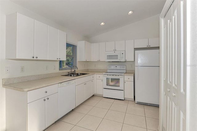 kitchen with a sink, white appliances, light countertops, light tile patterned floors, and lofted ceiling