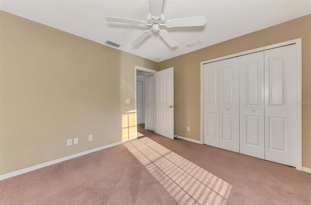 unfurnished bedroom with a closet, visible vents, carpet flooring, and baseboards