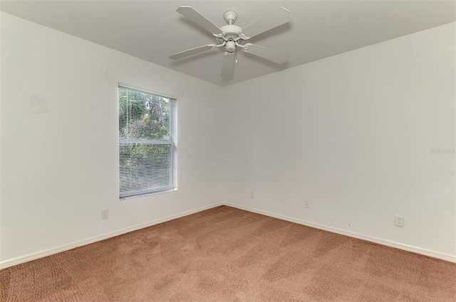 empty room with baseboards, light colored carpet, and ceiling fan