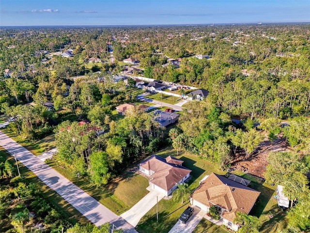 drone / aerial view with a wooded view and a residential view