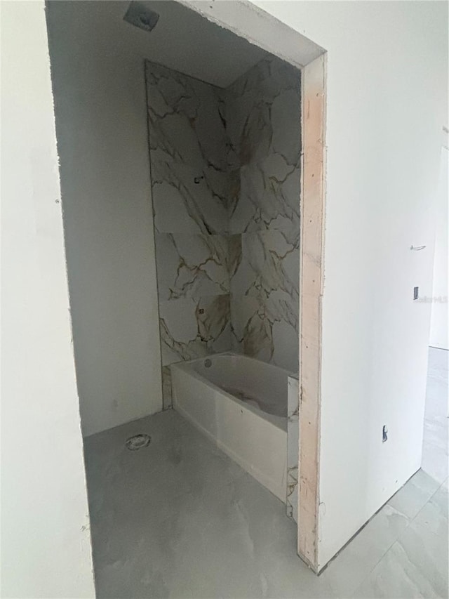 bathroom featuring a bathtub and marble finish floor