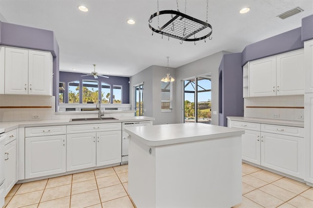 kitchen featuring dishwasher, light tile patterned floors, visible vents, and a sink