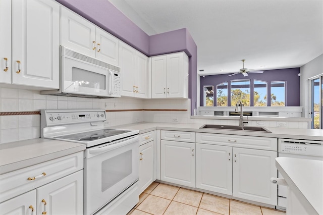 kitchen with white appliances, a sink, light countertops, tasteful backsplash, and a wealth of natural light