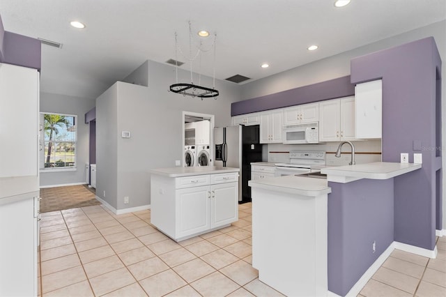 kitchen featuring white appliances, light tile patterned flooring, light countertops, white cabinets, and washer and clothes dryer