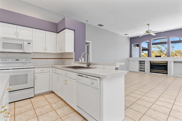 kitchen with white appliances, a peninsula, light tile patterned flooring, a sink, and wine cooler