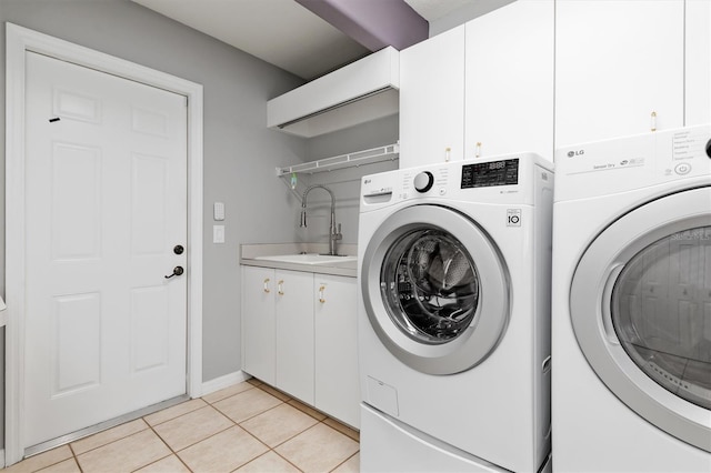 laundry room featuring a sink, cabinet space, washing machine and dryer, and light tile patterned flooring