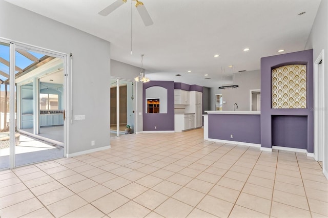 unfurnished living room with baseboards, light tile patterned flooring, recessed lighting, a sink, and ceiling fan with notable chandelier