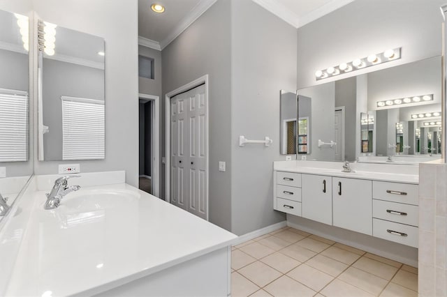 bathroom featuring tile patterned floors, two vanities, crown molding, and a sink