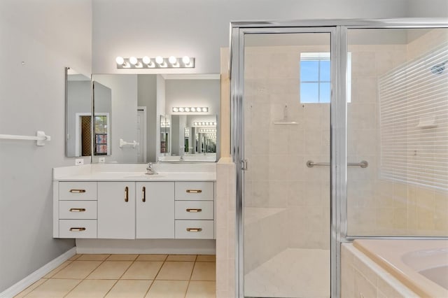 bathroom featuring baseboards, a relaxing tiled tub, a stall shower, tile patterned floors, and vanity