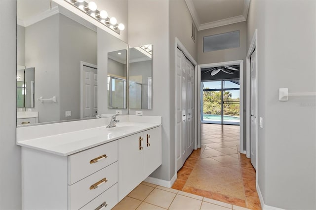 bathroom with tile patterned flooring, crown molding, baseboards, vanity, and a ceiling fan