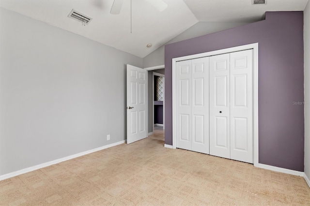 unfurnished bedroom featuring baseboards, visible vents, carpet floors, and lofted ceiling