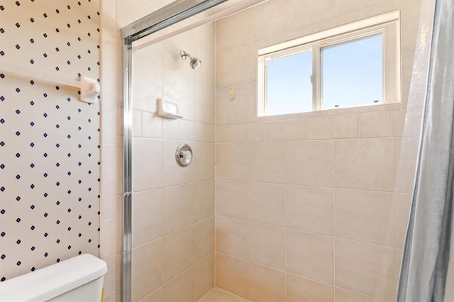 bathroom featuring a shower stall and toilet