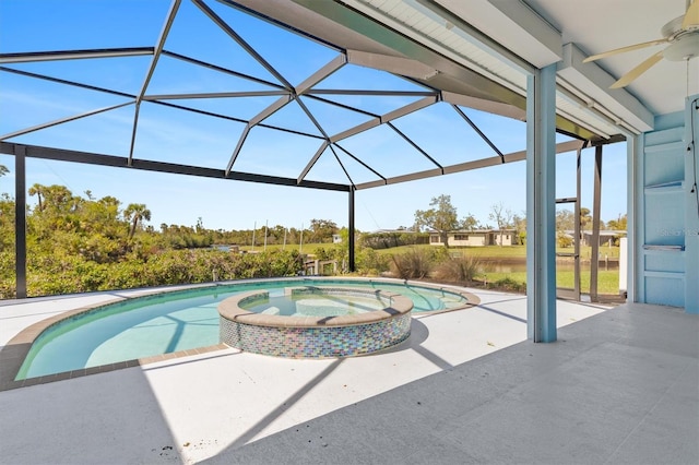 view of swimming pool featuring a patio area, glass enclosure, a pool with connected hot tub, and ceiling fan