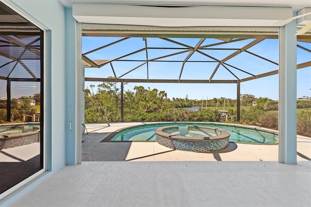 view of swimming pool with glass enclosure, a patio area, and a pool with connected hot tub