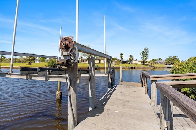 view of dock with boat lift and a water view