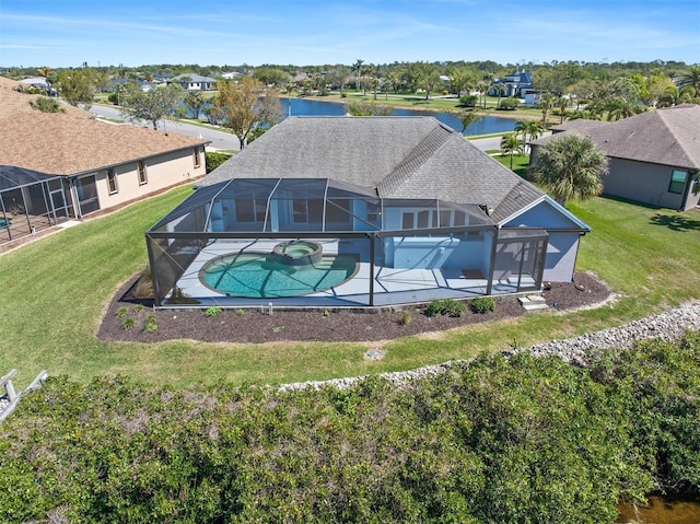 exterior space featuring a lanai, a patio area, a pool with connected hot tub, and roof with shingles