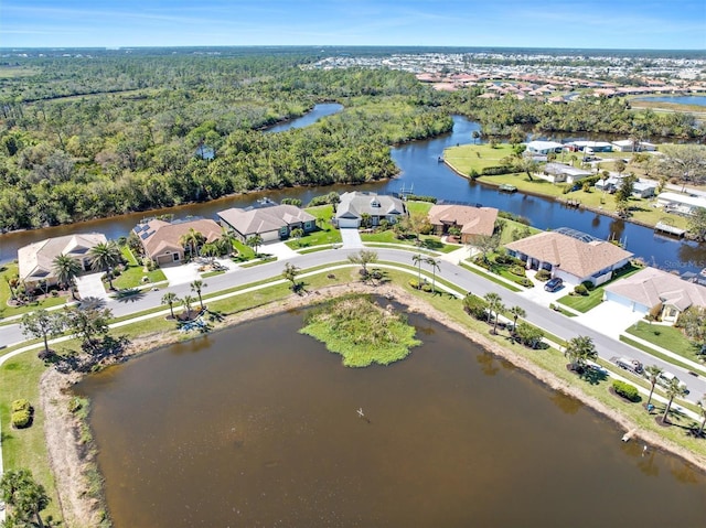 drone / aerial view with a residential view, a water view, and a wooded view