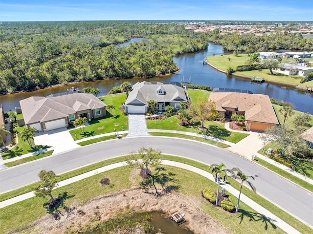 birds eye view of property featuring a residential view, a forest view, and a water view