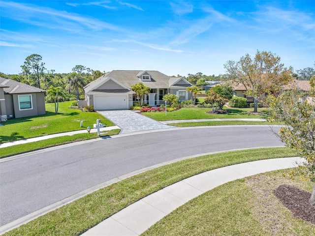 view of front of house with decorative driveway, an attached garage, and a front yard