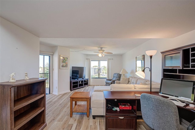 living room with light wood-type flooring, baseboards, and ceiling fan