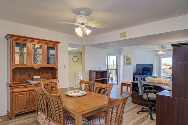 dining space with light wood-type flooring, plenty of natural light, and a ceiling fan