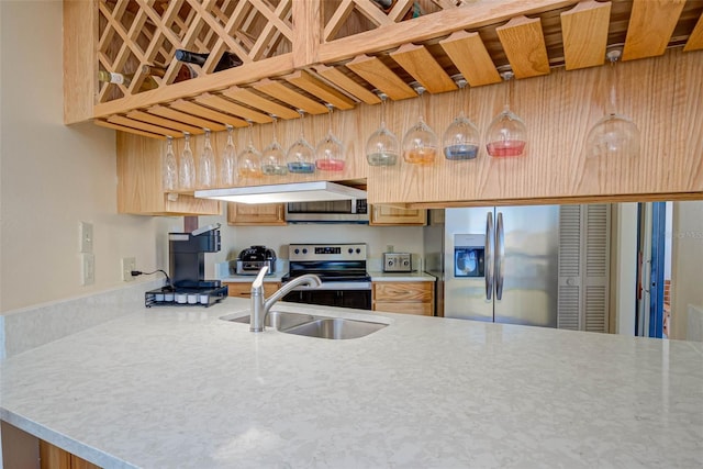 kitchen featuring light countertops, under cabinet range hood, appliances with stainless steel finishes, and a sink