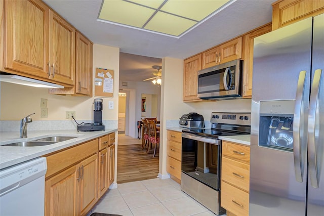 kitchen featuring light countertops, light tile patterned flooring, appliances with stainless steel finishes, and a sink