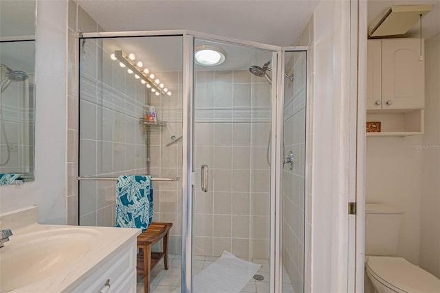 bathroom with tile patterned floors, toilet, a stall shower, and vanity