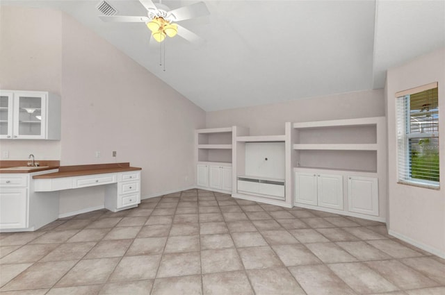 interior space with visible vents, baseboards, ceiling fan, vaulted ceiling, and a sink