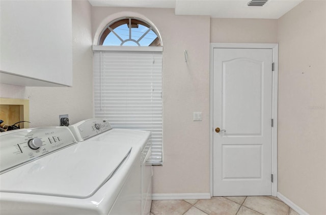 laundry area with baseboards, cabinet space, light tile patterned flooring, and washing machine and clothes dryer